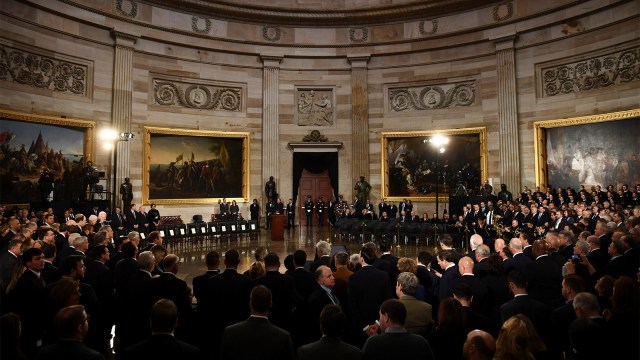 Orang-orang menunggu peti mati mantan Presiden AS George HW Bush tiba di Capitol AS di Washington. (Foto: Pool via Reuters)