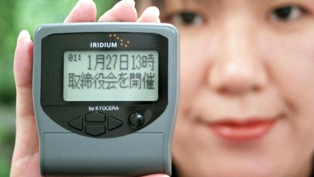 Seorang karyawan Nippon Iridium menunnjukan pager layanan telepon satelit Iridium di Tokyo, Jepang (28/12/1998). (Foto: AFP/YOSHIKAZU TSUNO)