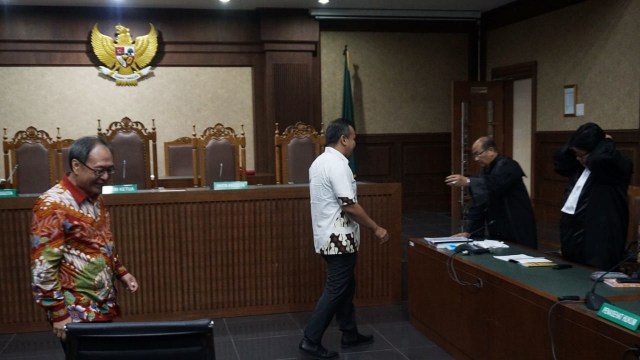 Made Oka Masagung (kiri) dan Irvanto Hendra Pambudi (kedua kiri) menghampiri penasihat hukum saat sidang putusan di Pengadilan Tindak Pidana Korupsi, Jakarta, Rabu (5/12/2018). (Foto: Jamal Ramadhan/kumparan)