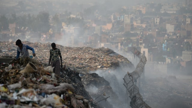 Sejumlah orang sedang mengumpulkan sampah pembuangan sampah di situs TPA Bhalswa di New Delhi. (Foto:  AFP/ SAJJAD HUSSAIN)