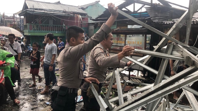 Sejumlah anggota polisi Polresta Kota Bogor membantu membersihkan puing-puing bangunan yang hancur  akibat puting beliung di kota Bogor. (Foto: Dok. Polresta Kota Bogor)