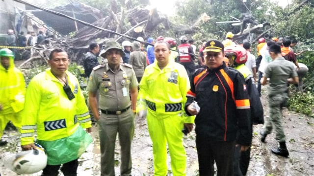 Sejumlah anggota polisi Polresta Kota Bogor membantu membersihkan batang pohon yang hancur akibat puting beliung di kota Bogor. (Foto: Dok. Polresta Kota Bogor)