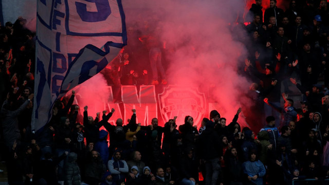 Suporter Napoli menyalakan suar di tribune Stadio San Paolo. (Foto: Reuters/Ciro De Luca)