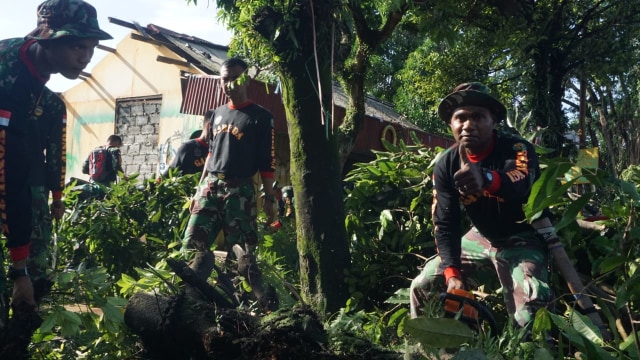 Petugas membersihkan sisa kerusakan akibat terdampak angin puting beliung di Cipaku, Bogor, Jumat (7/12/2018). (Foto: Abil Achmad Akbar/kumparan)