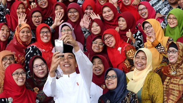 Presiden Joko Widodo berswafoto dengan pegawai ketika mengunjungi Universitas Aisyiyah di Yogyakarta, Kamis (6/12/2018). (Foto: Antara/Wahyu Putro A)