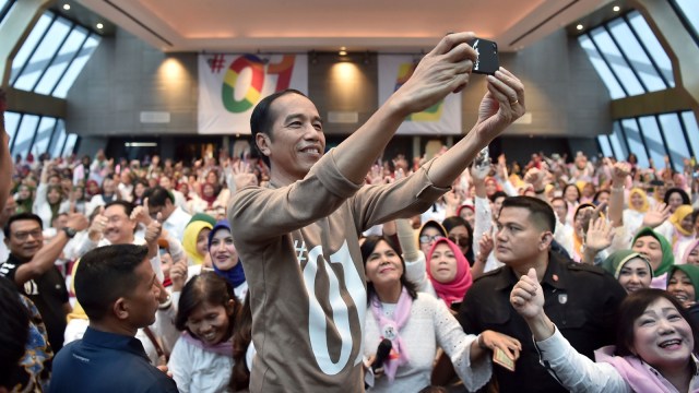 Calon presiden petahana Joko Widodo (tengah) berswafoto dengan para calon anggota legislatif saat deklarasi di Tangerang, Banten, Minggu (4/11/2018). (Foto: Antara/Puspa Perwitasari)