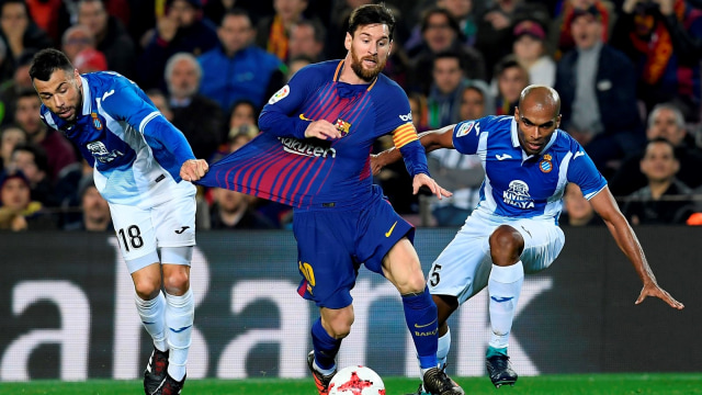 Messi melewati adangan dua pemain Espanyol. (Foto: AFP/Lluis Gene)