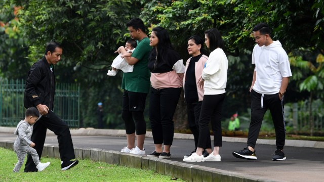 Presiden Joko Widodo (kedua kiri) menggandeng cucu Jan Ethes (kiri) bersama Ibu Negara Iriana Joko Widodo dan keluarga di Kebun Raya Bogor. (Foto: ANTARA FOTO/Wahyu Putro A)