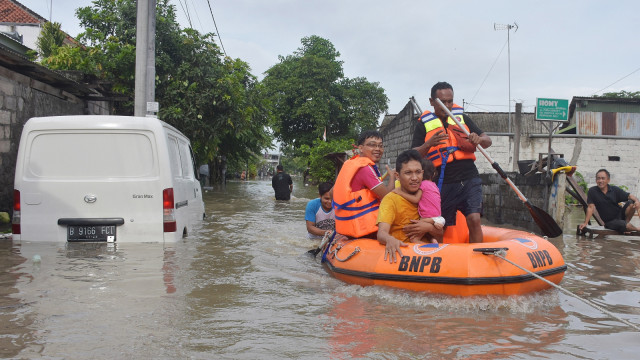 Petugas BNPB mengevakuasi warga akibat banjir di kawasan perumahan jalan Pura Demak, Denpasar, Sabtu (8/12/2018).  (Foto: ANTARA FOTO/Adhi Prayitno)