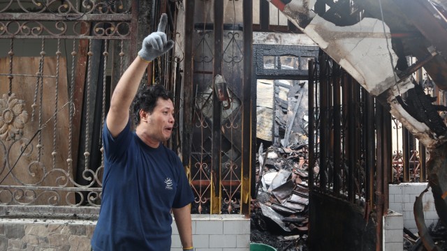 Ferry Pranoto  menunjukan sisa-sisa kebakaran rumah dan toko miliknya di Kapasan , Surabaya.  (Foto: Nuryatin Phaksy Sukowati/kumparan)