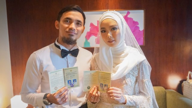 Lindswell Kwok dan Achmad Hulaefi menunjukan buku pernikahan. (Foto: Dok. Promessa Weddings)