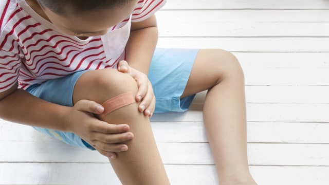 Ilustrasi anak memakai plester luka di lututnya Foto: Shutterstock