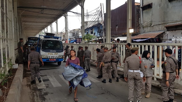 Satpol PP lakukan penertiban di trotoar bagian bawah Skybridge Tanah Abang, Senin (10/12). (Foto: Efira Tamara/kumparan)