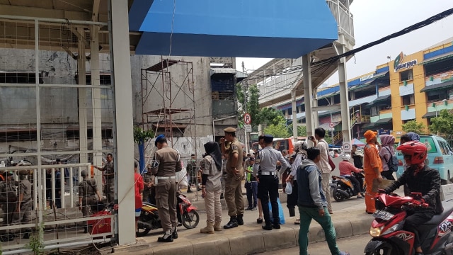 Satpol PP lakukan penertiban di trotoar bagian bawah Skybridge Tanah Abang, Senin (10/12). (Foto: Efira Tamara/kumparan)