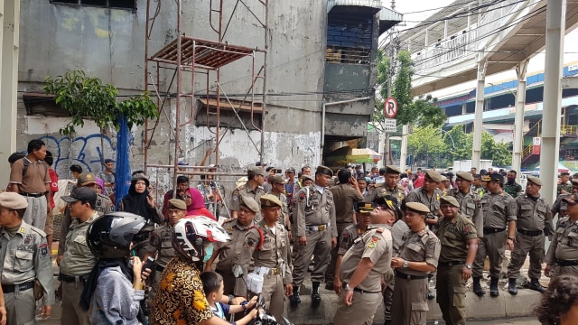 Satpol PP lakukan penertiban di trotoar bagian bawah Skybridge Tanah Abang, Senin (10/12). (Foto: Efira Tamara/kumparan)