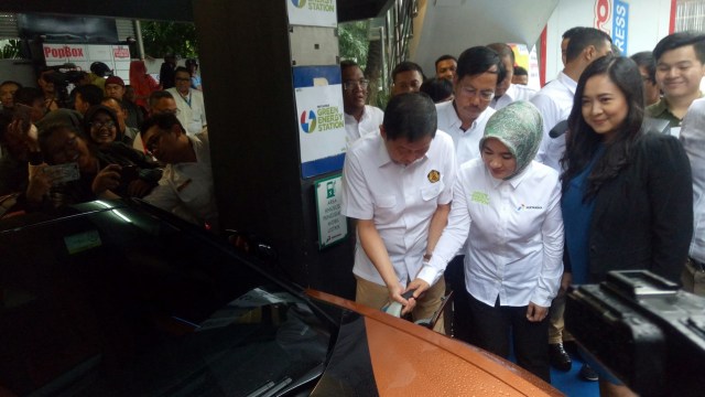 Menteri ESDM Ignasius Jonan bersama Direktur Utama Pertamina Nicke Widyawati mengisi daya pada mobil listrik
 (Foto: Resya Firmansyah/kumparan)