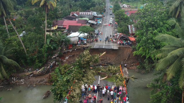 Sejumlah warga menyaksikan jembatan yang roboh di Jalan Raya Padang - Bukittinggi, Kayutanam, Sumatera Barat, Selasa (11/12/ (Foto: ANTARA FOTO/Iggoy el Fitra)