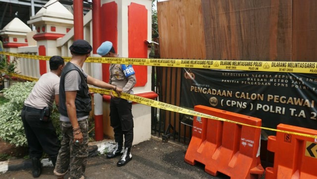Petugas kepolisian memasang garis polisi di Polsek Ciracas, Jakarta Timur, Rabu (12/12).