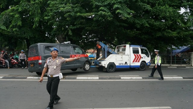 Sejumlah mobil yang dirusak massa di Polsek Ciracas, Jakarta Timur diderek petugas, Rabu (12/12). (Foto: Nugroho Sejati/kumparan)