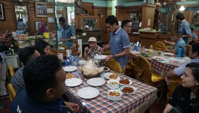 Cawapres nomor urut 2 Sandiaga Uno saat mengambilkan nasi untuk wartawan. (Foto: Helmi Afandi Abdullah/kumparan)