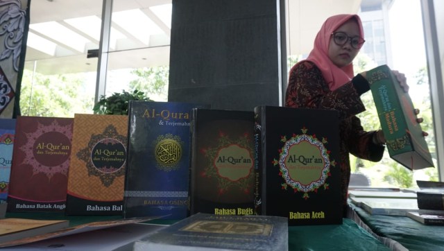 Seorang petugas dari Kementrian Agama merapihkan al-quran terjemah 3 bahasa daerah Aceh,  Bugis dan Madura. (Foto: Helmi Afandi Abdullah/kumparan)