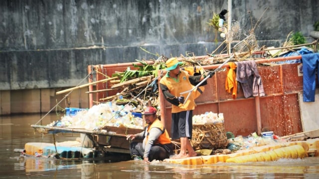 Petugas PPSU sedang memunguti sampah yang bertebaran terbawa arus air Kali Angke, di kawasan Kali Pojok, Tambora, Jakarta Barat, Kamis (13/12). (Foto: Iqbal Firdaus/kumparan)