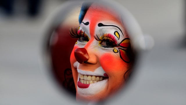 Seorang badut tersenyum di cermin dalam memperingati  International Clown Day di Guadalajara, Meksiko. (Foto: AFP/Ulises Ruiz)