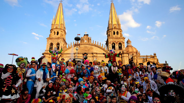 Sejumlah badut berfoto bersama memperingati  International Clown Day  dengan latar belakang Gereja Katedral di Guadalajara, Meksiko. (Foto: AFP/Ulises Ruiz)