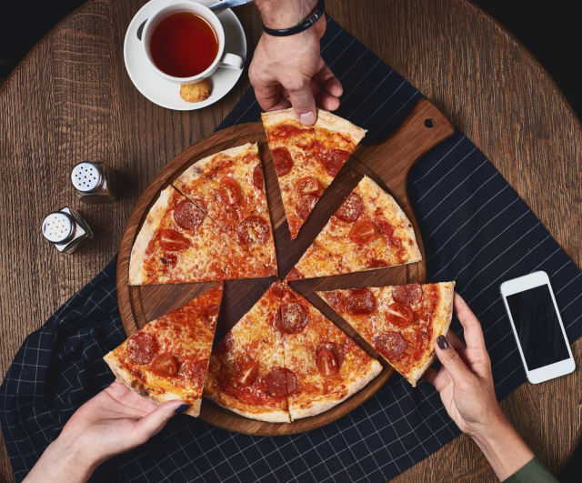 Ilustrasi makan pizza Foto: Shutter Stock