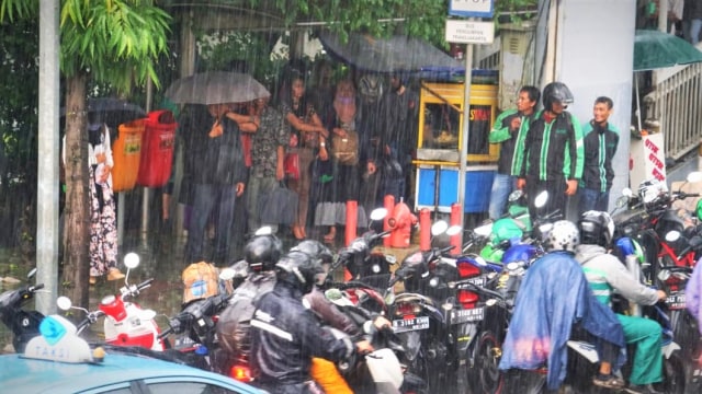 Suasana Jalan Gatot Subroto ketika dilanda hujan, pengendara motor berteduh di bawah JPO menyebabkan arus lalu lintas sedikit tersendat. Foto: Iqbal Firdaus/kumparan