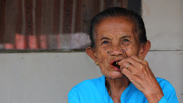 Seorang perempuan tua sedang menyirih. (Foto: Riedoak via wikimedia commons)