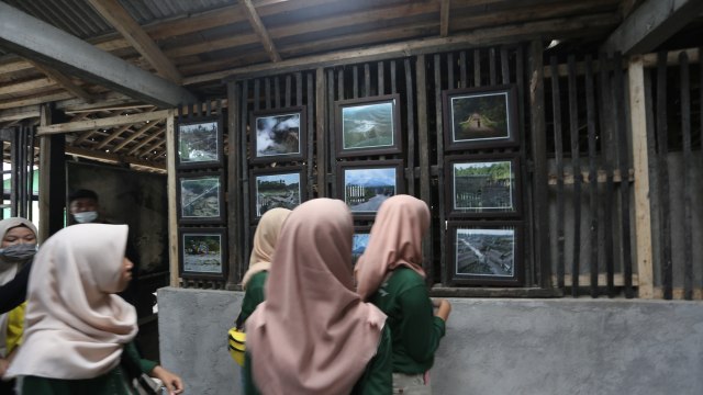 Pengunjung sedang melihat dokumentasi erupsi Gunung Merapi (Foto: Aria Sankhyaadi/kumparan)