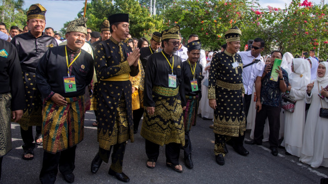 Presiden Joko Widodo (tengah) mengenakan baju tradisional Melayu saat menyapa warga di Kota Pekanbaru, Riau, Sabtu (15/12/2018).  (Foto: ANTARA FOTO/FB Anggoro)