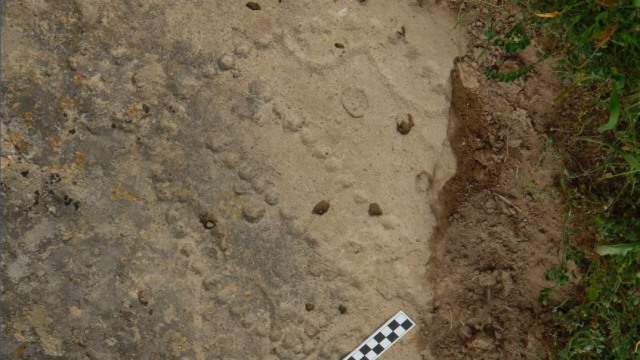 Pola khas dari cetakan lubang di batu yang ditemukan di Taman Nasional Gobustan, Azerbaijan. (Foto: Walter Crist/Taman Nasional Gobustan)