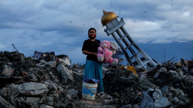 Seorang perempuan saat memegang boneka kelinci setelah gempa dan tsunami menghancurkan rumahnya. Dalam kejadian tersebut, Ia juga kehilangan tiga anaknya, Palu, Sulawesi Tengah (7/10/2018) (Foto: REUTERS/Jorge Silva)