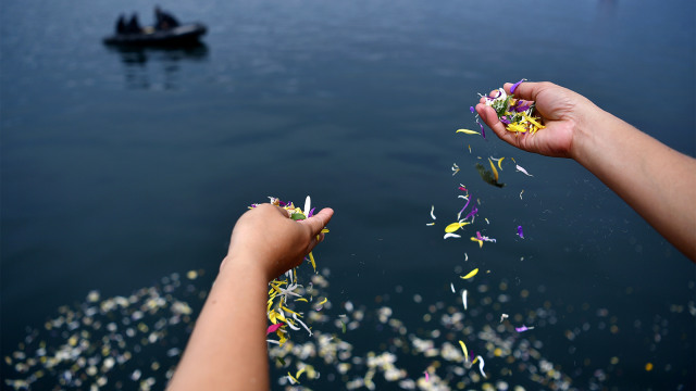Keluarga korban KM Sinar Bangun menabur bunga di Danau Toba (18/6/2018). (Foto: Antara/Sigid Kurniawan)