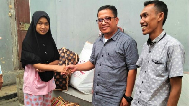 sekretaris Dinas Sosial Aceh, Devi Riansyah (tengah) memberikan bantuan kepada Magfirah (27) (kiri) berupa perlengkapan bayi untuk ke tiga bayi. (Foto: Dok. Dinsos Aceh)