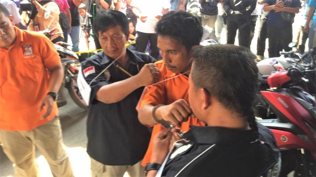Tersangka Iwan Hutapea pukul Komarudin saat adegan rekonstruksi di Polda Metro Jaya. (Foto: Mirsan Simamora/kumparan)