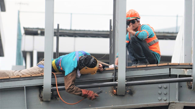 Pekerja melakukan pengerjaan proyek revitalisasi Jembatan Penyeberangan Orang (JPO) Bundaran Senayan di Jakarta, Selasa (18/12). (Foto: Iqbal Firdaus/kumparan)