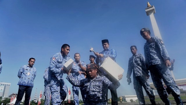 Gubernur DKI Jakarta Anies Baswedan memukul batako menggunakan palu saat atraksi kekuatan tarung derajat di Lapangan Silang Monas Selatan, Jakarta Pusat. (Foto: Irfan Adi Saputra/kumparan)