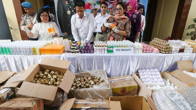 Polisi dan Petugas Balai Besar Pengawas Obat dan Makanan (BBPOM) Surabaya menunjukkan barang bukti saat ungkap kasus kosmetik ilegal, Surabaya. (Foto: Antara/Didik Suhartono)