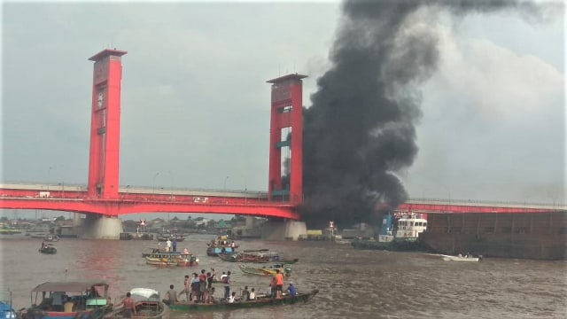 Kapal yang membawa muatan minyak terbakar di bawah jembatan Ampera Palembang. (Foto: Istimewa)