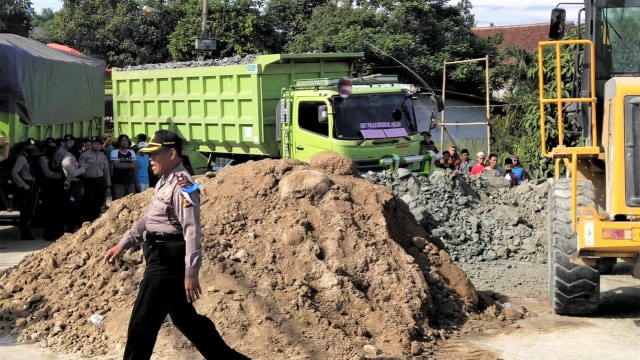 Polres Bogor, Polda Jabar bersama masyarakat melakukan pembersihan material berupa batu brangkal di Jalan Raya Parung Panjang. (Foto: Dok. Polres Bogor)
