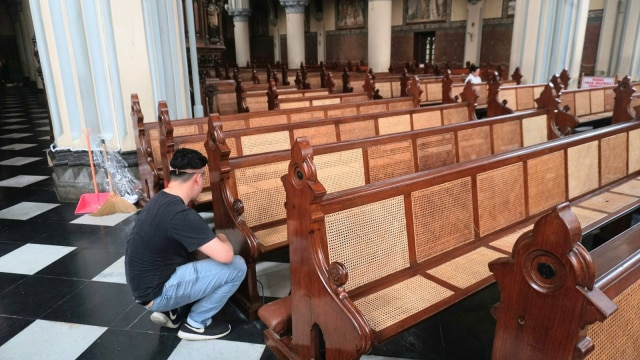 Sejumlah petugas membersihkan kursi yang akan digunakan saat Hari Raya Natal di Gereja Katedral, Jakarta, Sabtu (22/12). (Foto: Nugroho Sejati/kumparan)