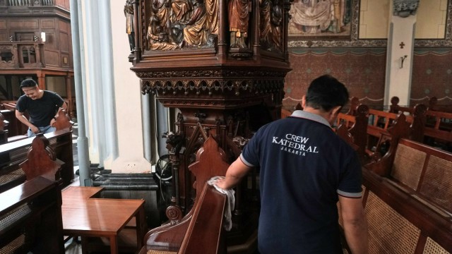 Sejumlah petugas membersihkan kursi yang akan digunakan saat Hari Raya Natal di Gereja Katedral, Jakarta, Sabtu (22/12). (Foto: Nugroho Sejati/kumparan)