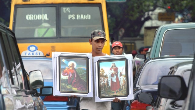 Seorang pria menjual gambar Yesus di Jakarta, 29 Juni 2004. (Foto: AFP/Farjana K. Godhuly)