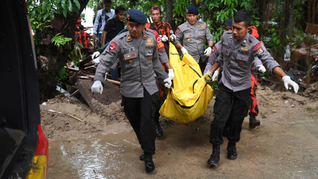 Polisi dan relawan mengevakuasi korban tewas akibat tsunami yang tertimbun di bawah reruntuhan di kawasan Carita, Banten, Senin (24/12/2018).  (Foto: ANTARA FOTO/Akbar Nugroho Gumay)
