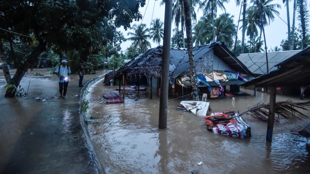 Warga melihat rumah penduduk yang terendam banjir di kampung Kadu Gareng, Desa Sukarame, Labuan, Banten, Rabu (26/12/2018).   (Foto: ANTARA FOTO/Muhammad Adimaja)