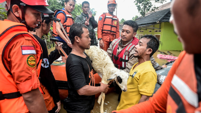 Petugas gabungan Basarnas, TNI dan Polri melakukan evakuasi  warga korban banjir menggunakan perahu di kampung Sentul, Desa Sukarame, Labuan, Banten, Rabu (26/12/2018).  (Foto: ANTARA FOTO/Muhammad Adimaja)