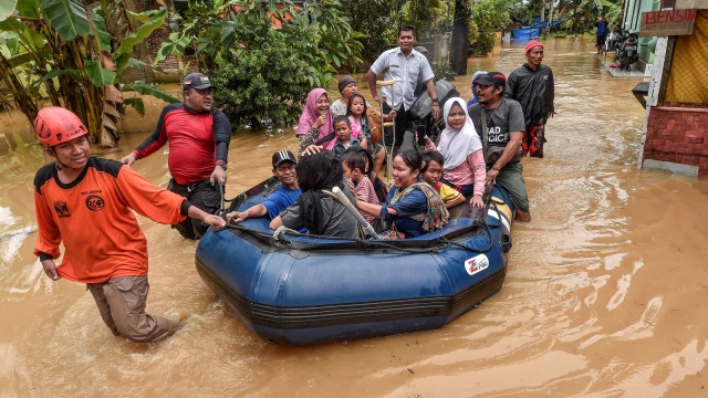 Petugas gabungan Basarnas, TNI dan Polri melakukan evakuasi  warga korban banjir menggunakan perahu di kampung Sentul, Desa Sukarame, Labuan, Banten, Rabu (26/12/2018).  (Foto: ANTARA FOTO/Muhammad Adimaja)